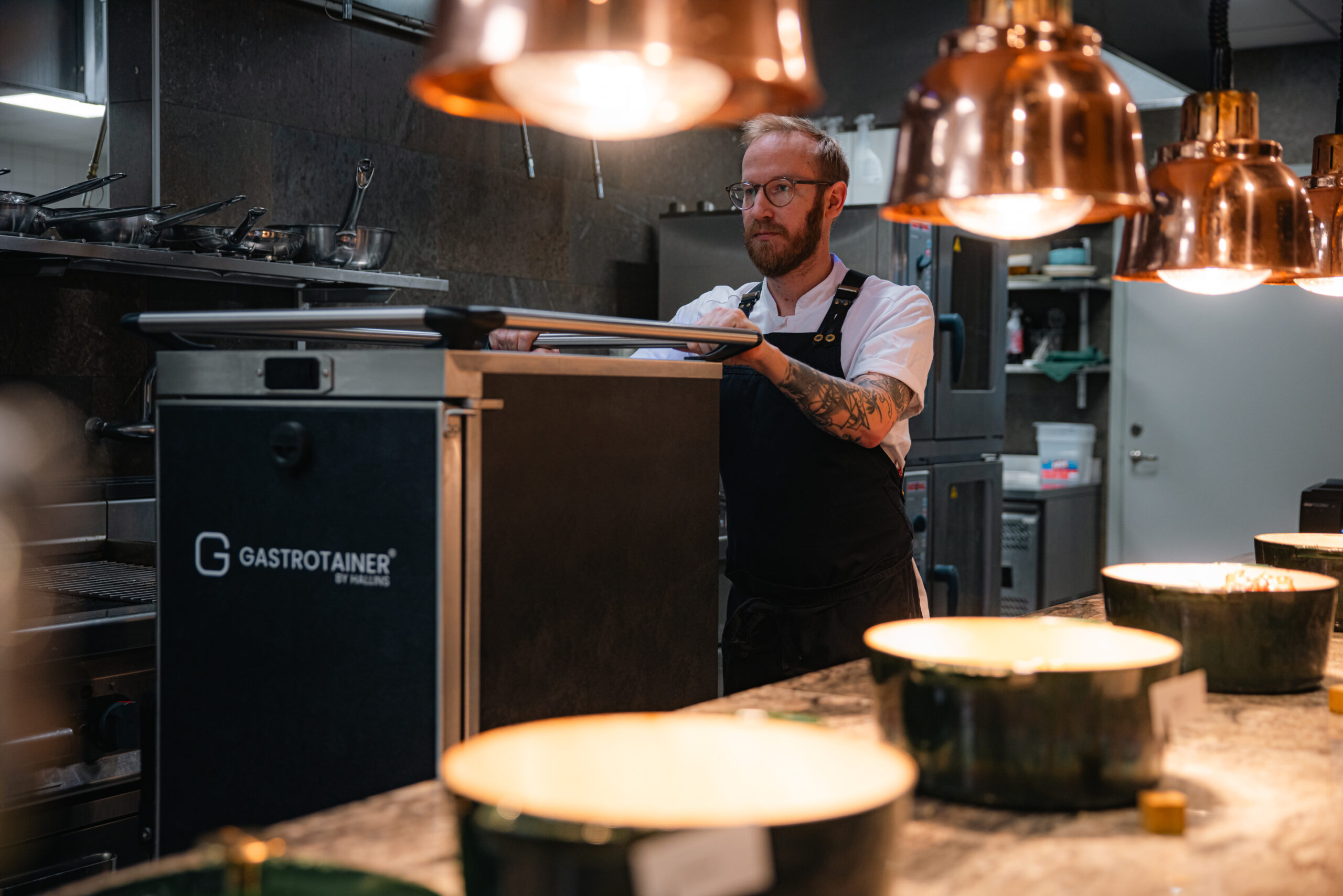 Kock hanterar Gastrotainer mattransportbox i storkök